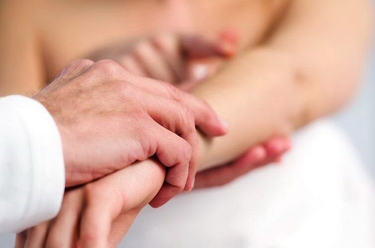 Dermatolog sedef hastalığı olan bir hastayı muayene ediyor